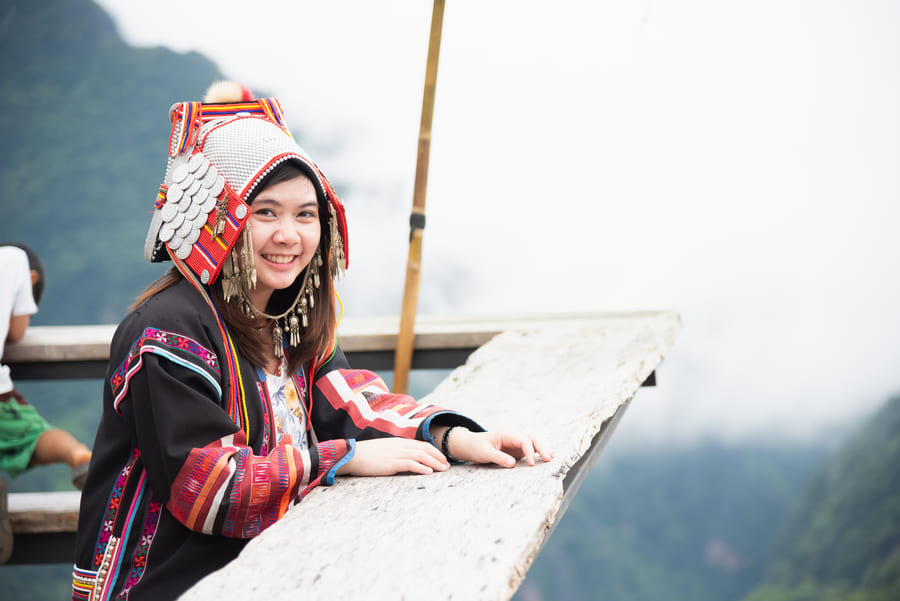 Mujer con vestimenta tradicional en un barco en Yunnan.